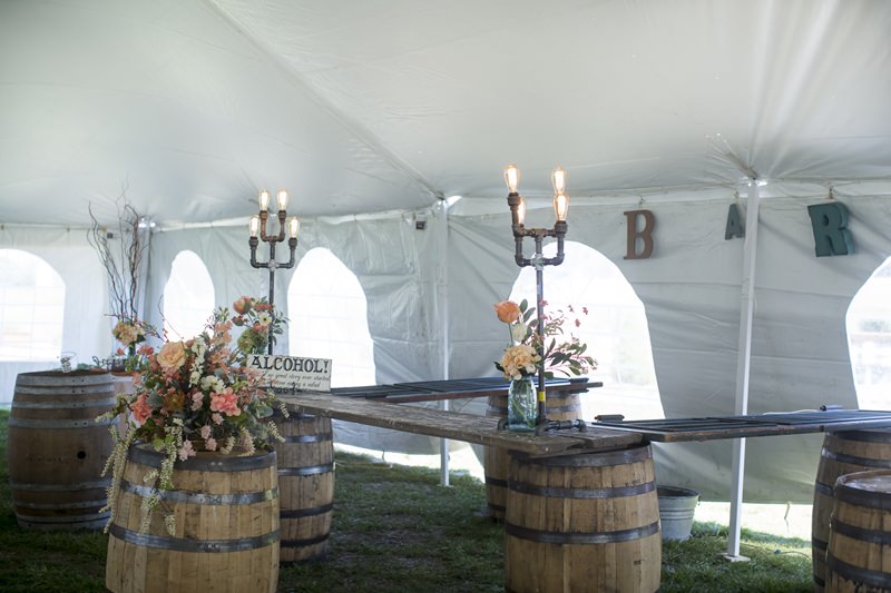 whiskey barrels drink bar in wedding tent by old oaks vintage rentals