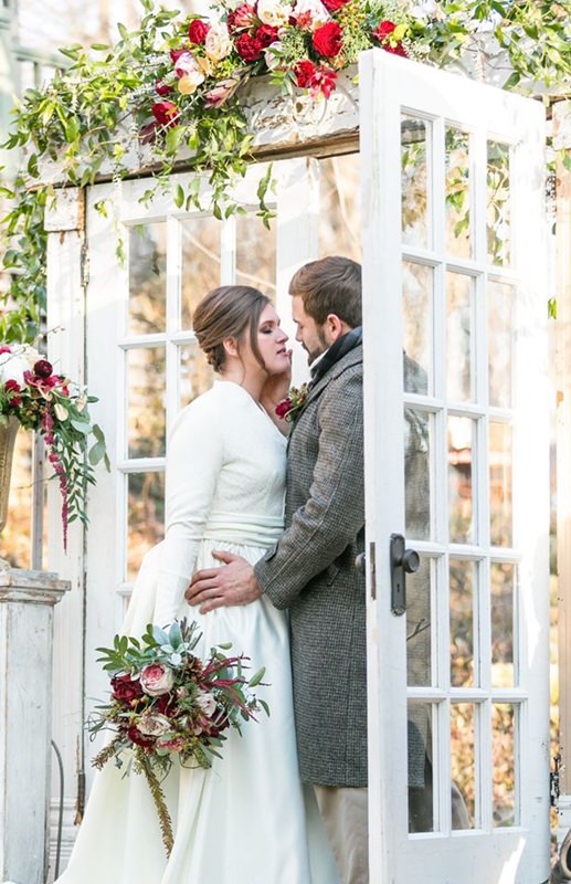 wedding vows under a vintage glass french door arch with flowers