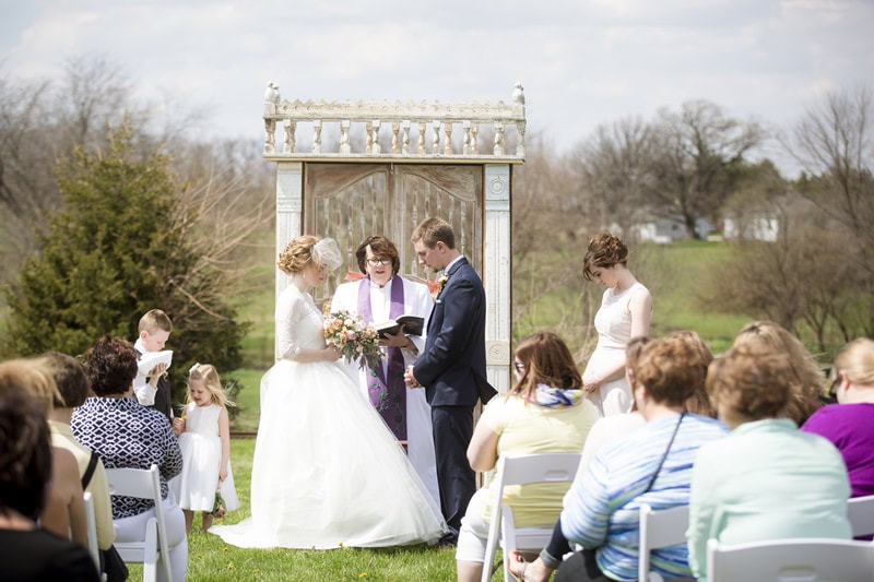outdoor wedding ceremony with vintage arch by old oaks vintage rentals